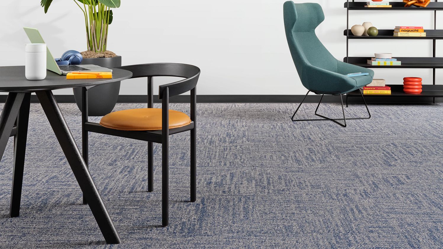 room with blue carpet tile, a table, and a chair