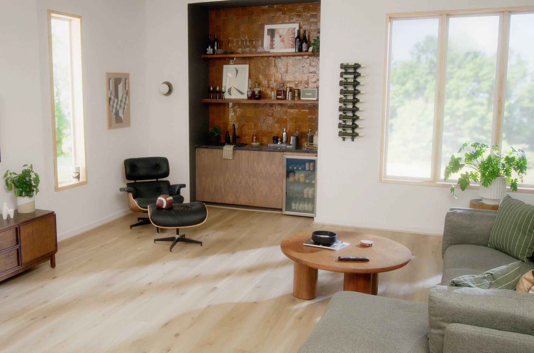 living room with light wood look luxury vinyl plank floor with a lounge chair coffee table and built-in bar area