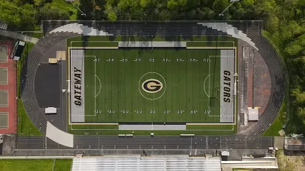 Scenic aerial shot of sports stadium and field Aerial view of a football field with track and surrounding greenery