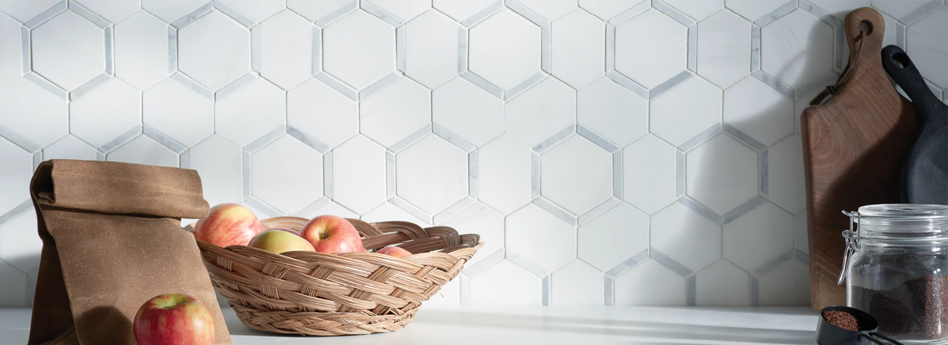 Cream Tile backsplash in a kitchen behind a coffee pot, cups and bowl of fruit