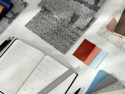 Commercial Carpet Tile Swatch Samples with Design Tools Swatch samples of commercial carpet tile in various shades of gray, blue, and beige with design tools on a desk