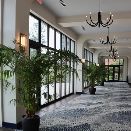 Stylish commercial carpet design for hospitality spaces Elegant hallway with modern chandeliers and wave-patterned carpet