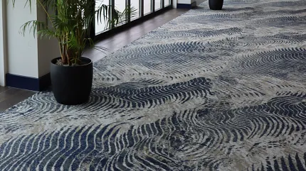 Stylish commercial carpet design for hospitality spaces Elegant hallway with modern chandeliers and wave-patterned carpet