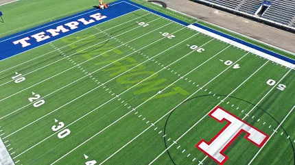 Artificial Turf Football Field with Temple Branding Aerial view of a football field with artificial turf featuring the word "TEMPLE" in blue and white end zone