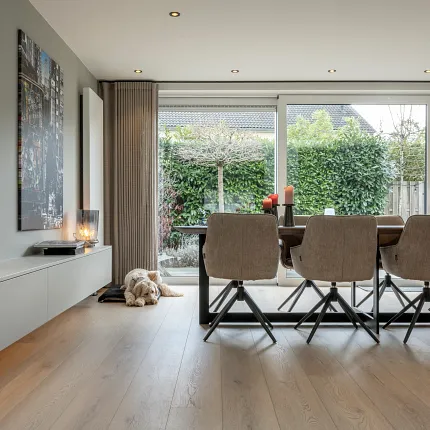 Licht eiken laminaatvloer voor een gezellige eetkamer sfeer Moderne eetkamer met licht eiken laminaatvloeren en bruine stoelen