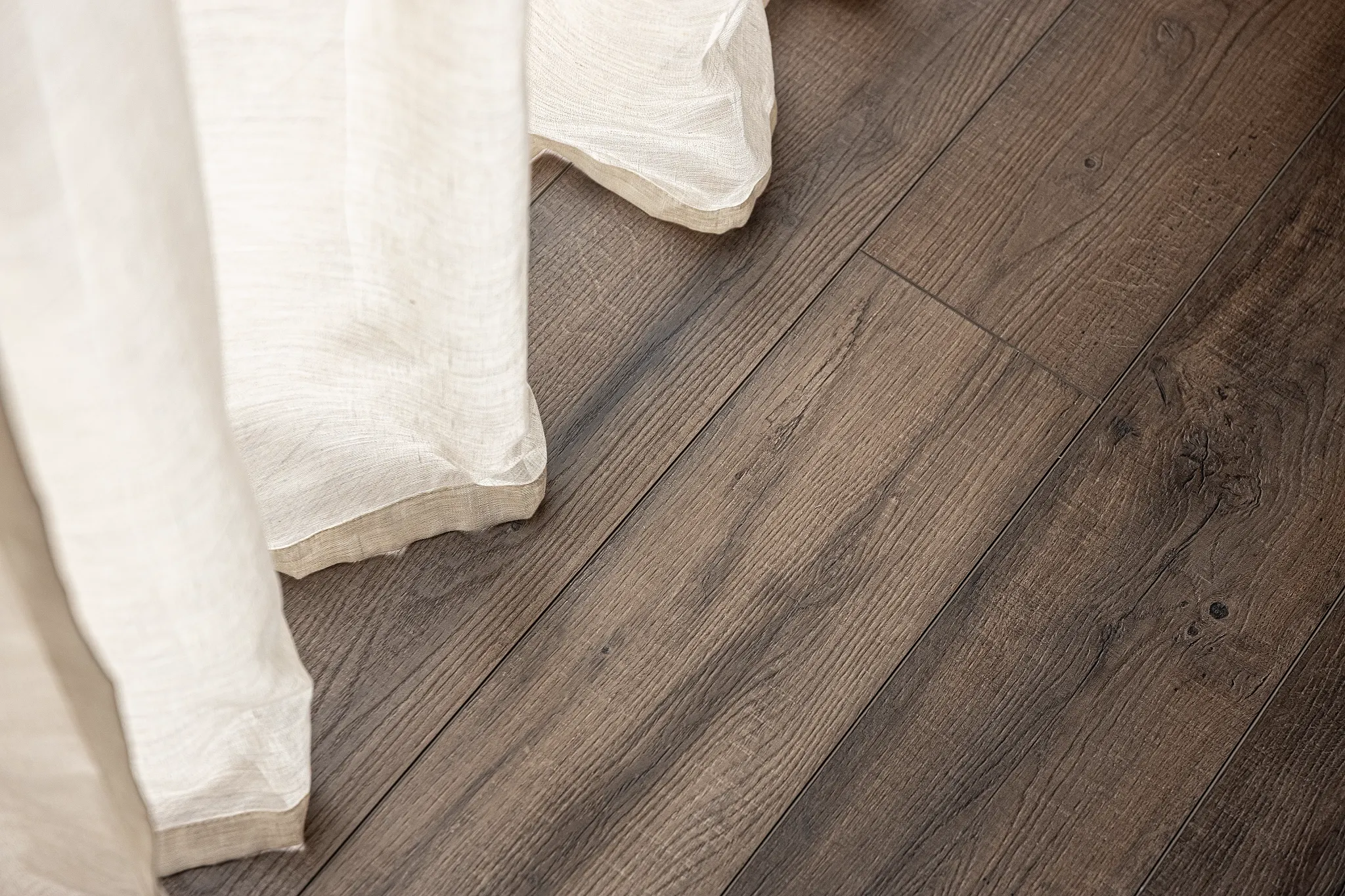Close-up Coretec wooden floor with curtains