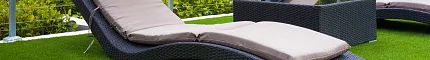Outdoor lounge chairs on artificial grass with city view