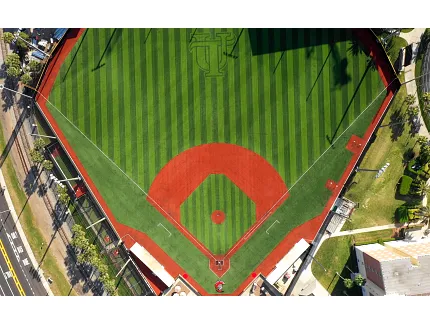 Baseball field with artificial turf and red clay areas from above Aerial view of a baseball field with artificial turf and red clay areas
