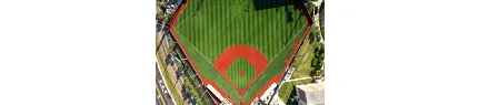 Baseball field with artificial turf and red clay areas from above Aerial view of a baseball field with artificial turf and red clay areas