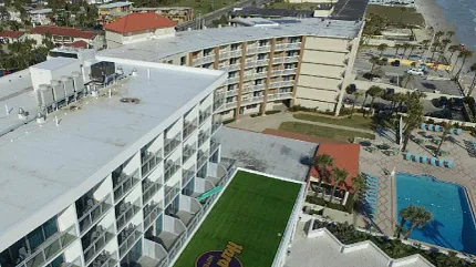 Scenic coastal hotel with rooftop branding Aerial view of beachfront hotel with rooftop logo
