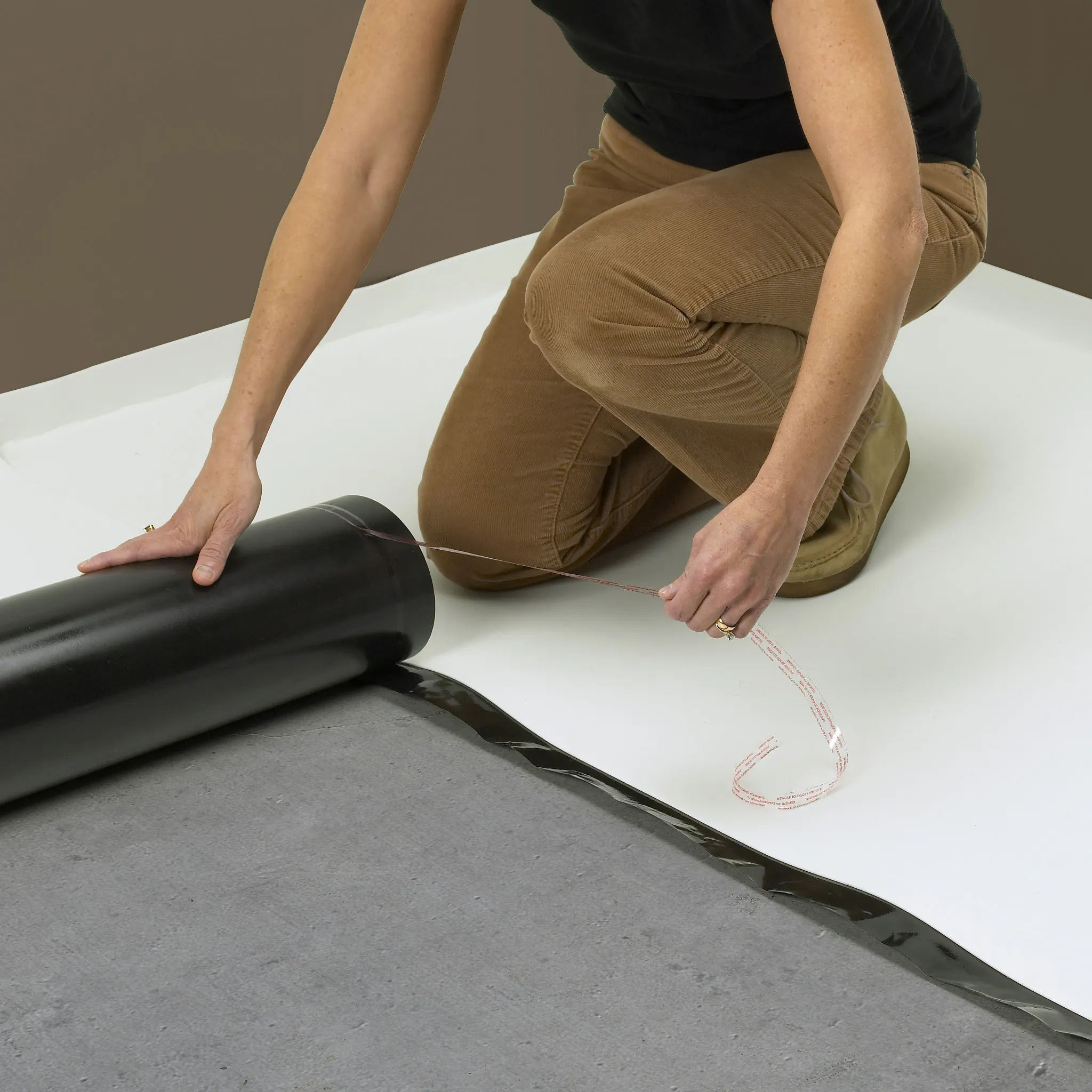 Woman installing underlayment for durable flooring