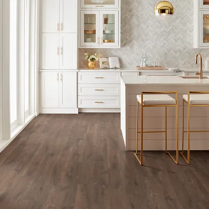 Stylish kitchen featuring durable laminate flooring for a cozy home atmosphere Modern kitchen with dark wood-look laminate flooring and white cabinetry