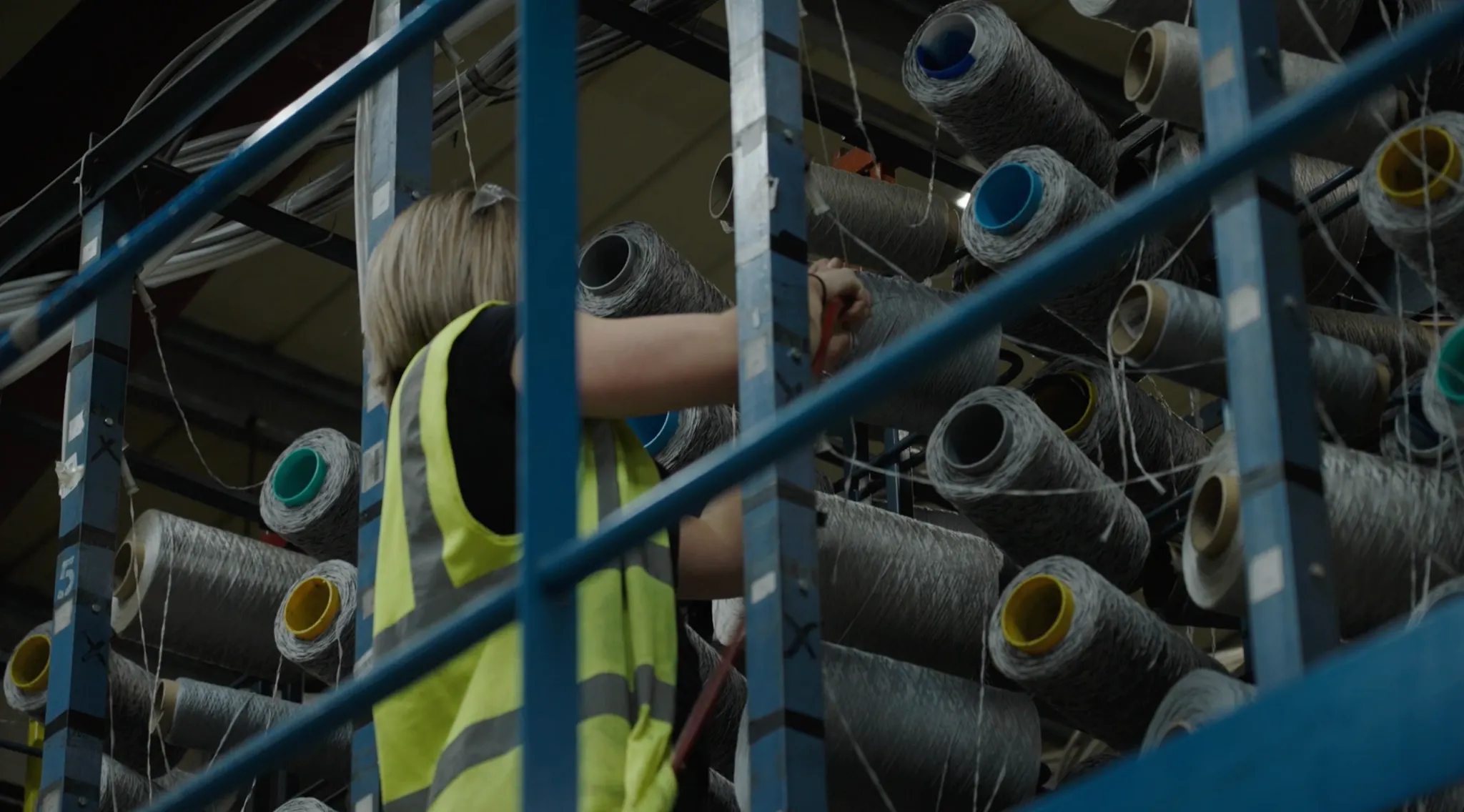 Industrial carpet manufacturing process with machinery and worker inspecting fabric