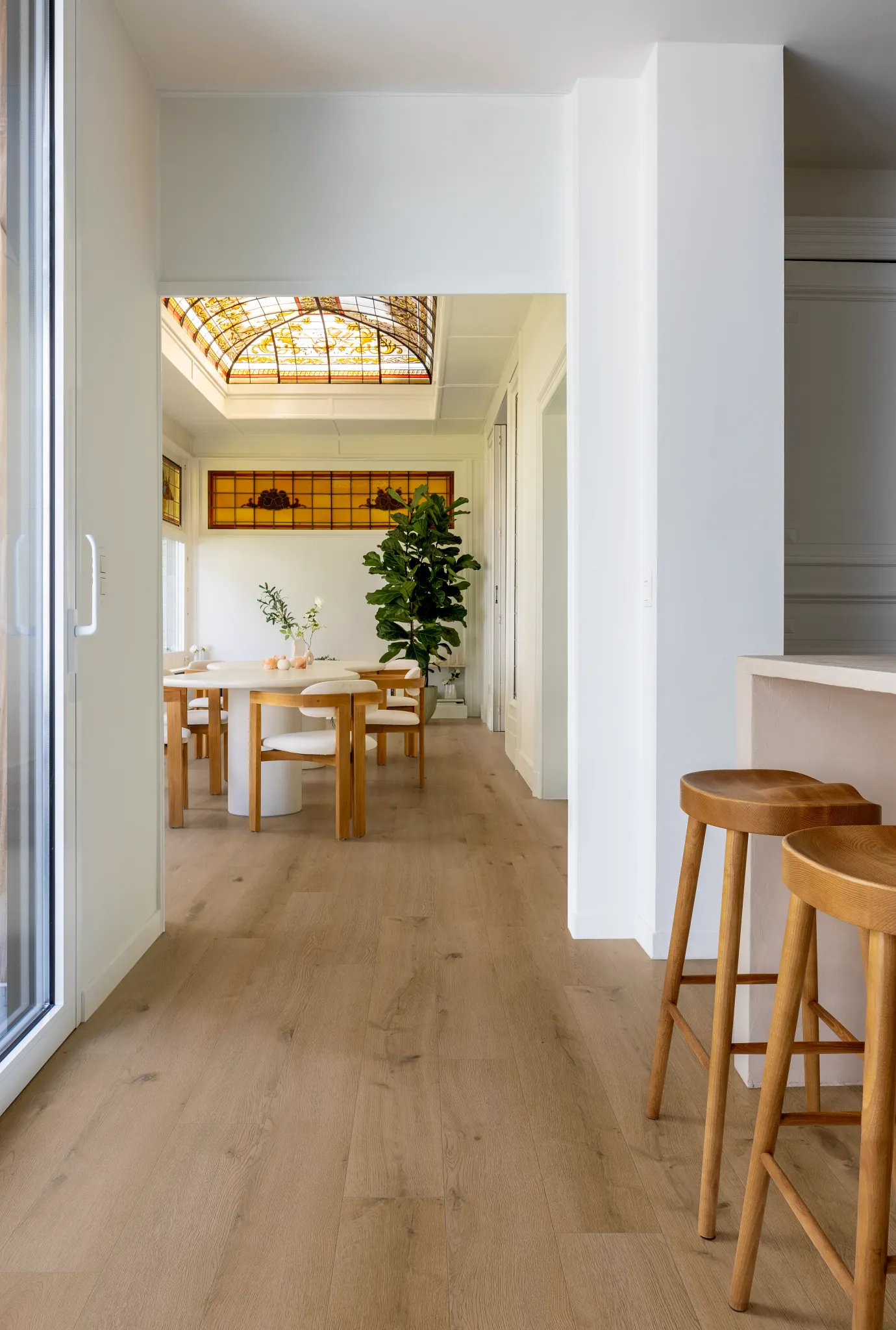 living room with luxury vinyl plank floor in a wood look design with a stylish black chair and  artwork on white brick walls