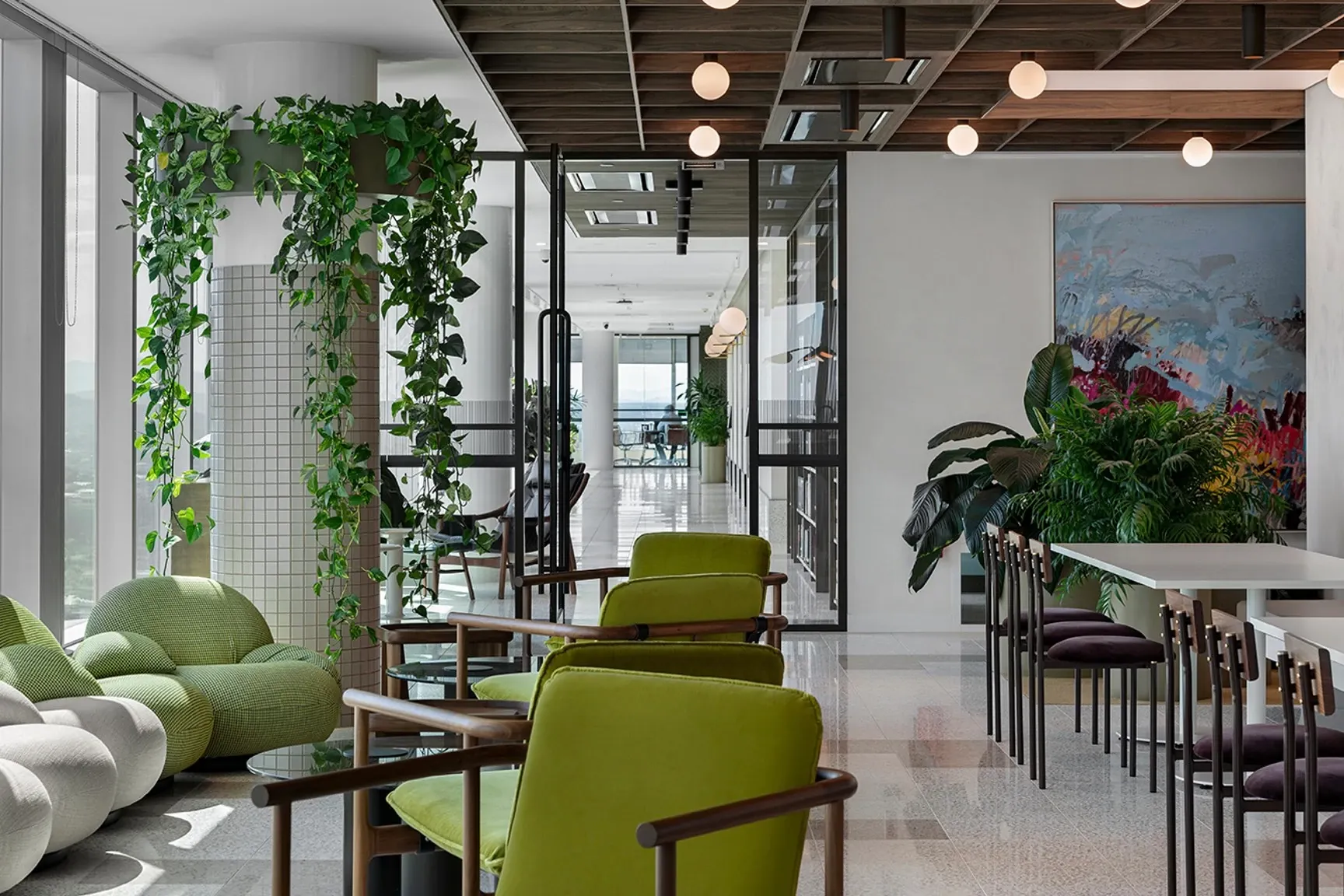 Sala de descanso de oficina moderna con sillas verdes y piso de terrazo