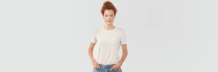 Casual fashion with white t-shirt and jeans for a relaxed look Young woman in casual white t-shirt and jeans standing against a plain background