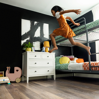 Young girl jumping off a bunk bed onto a COREtec floor