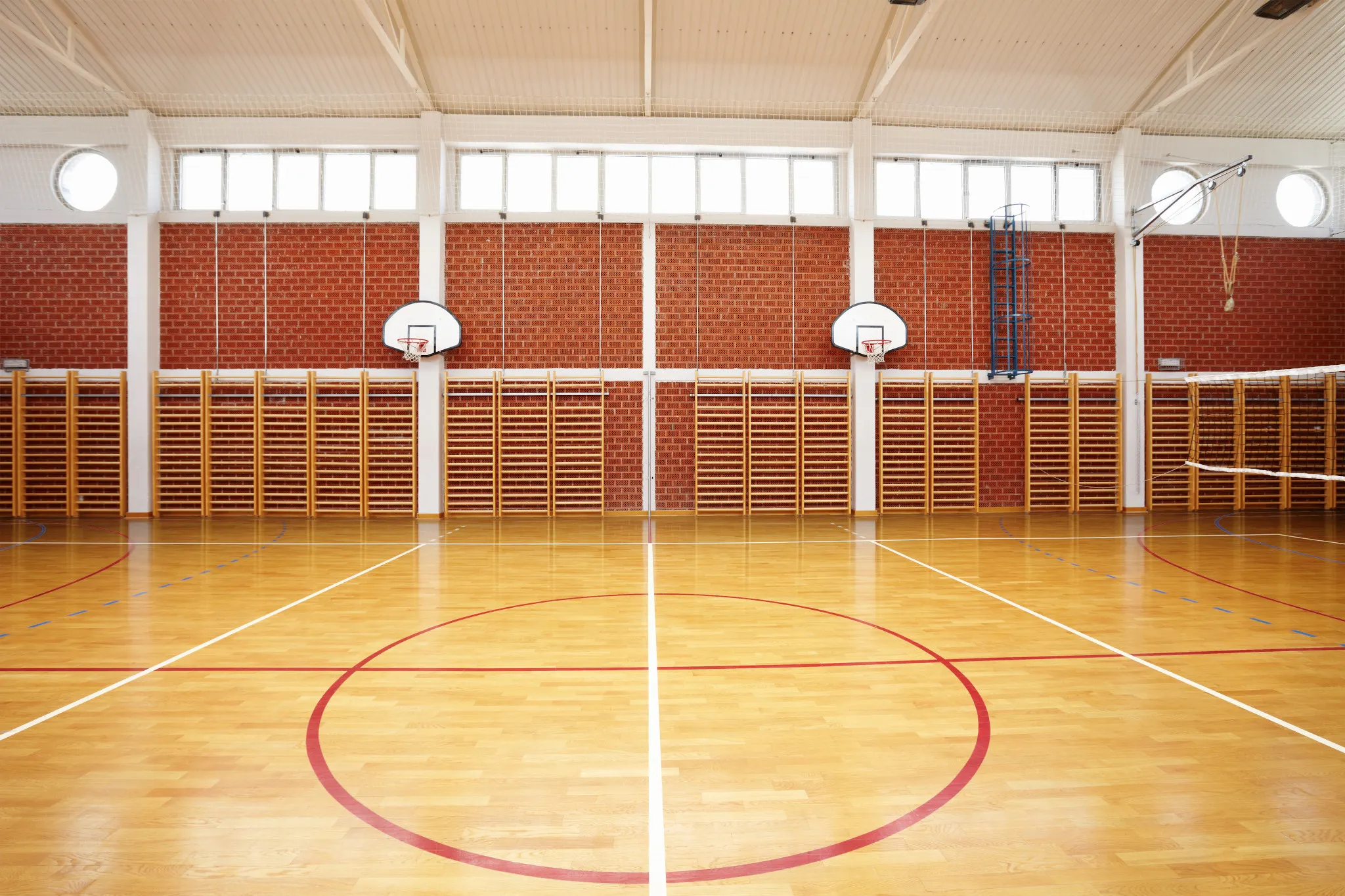 Indoor gymnasium with basketball hoops and commercial heterogeneous sheet vinyl flooring, 49.2x5.91 ft dimensions