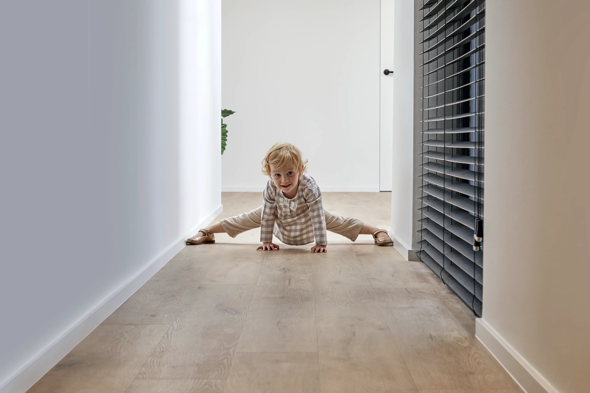 Child playing on light wood look luxury vinyl plank flooring in a modern hallway