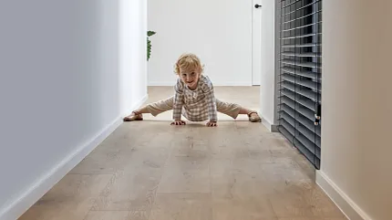 Light Wood Look LVP Flooring in Modern Hallway Scene Child playing on light wood look luxury vinyl plank flooring in a modern hallway