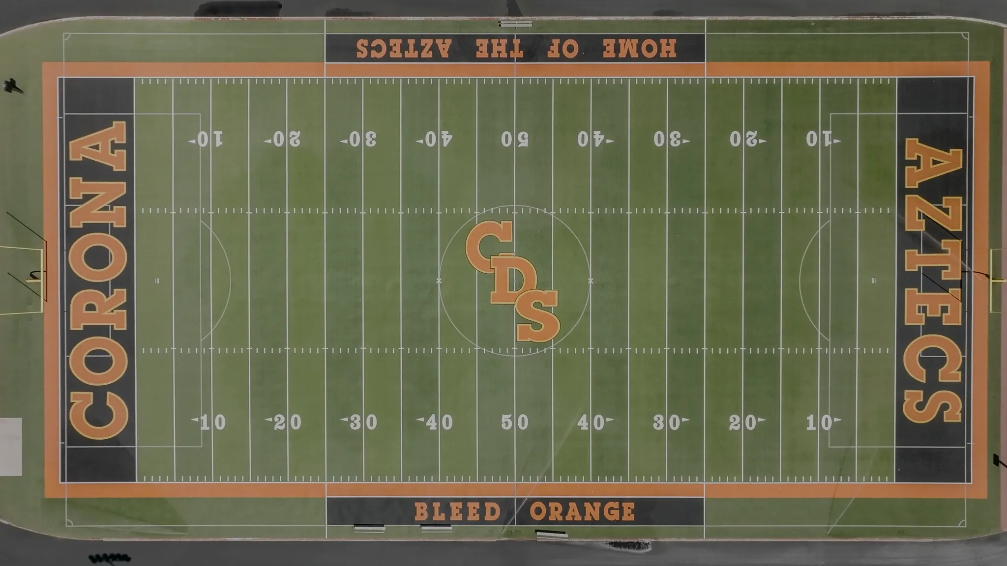 Aerial view of a football field with "Corona Aztecs" branding