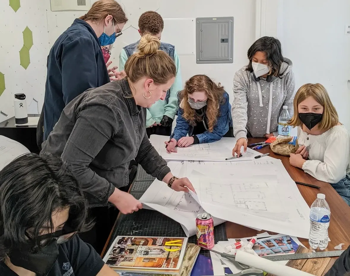 Group of people collaborating on design plans in a modern workspace