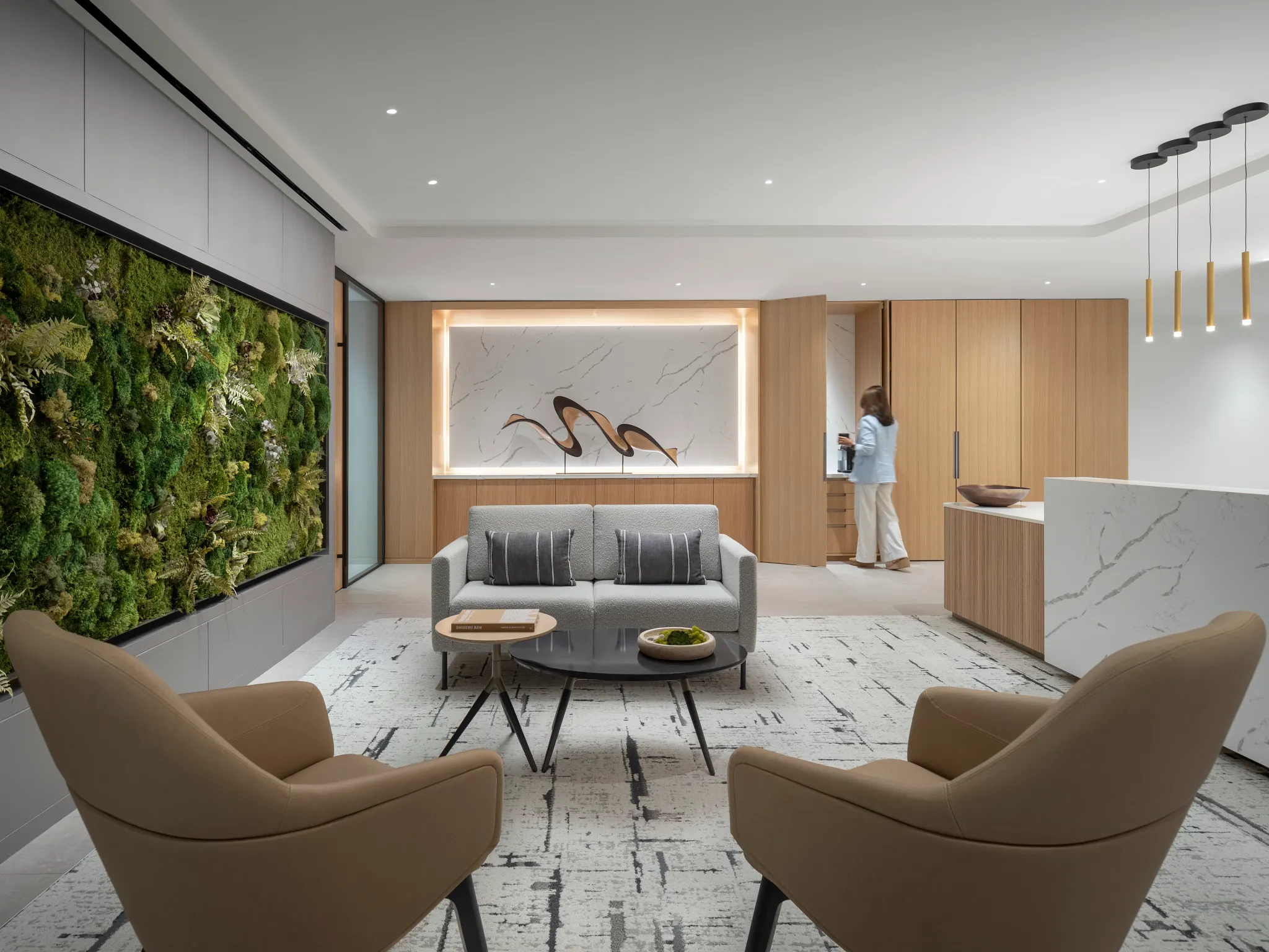 Modern workplace lounge area with contemporary furniture and a green wall