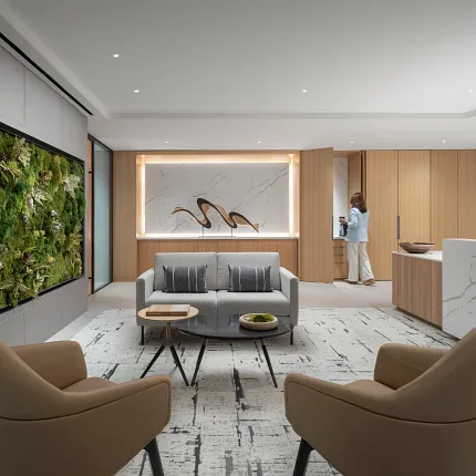 Modern workplace lounge area with contemporary furniture and a green wall