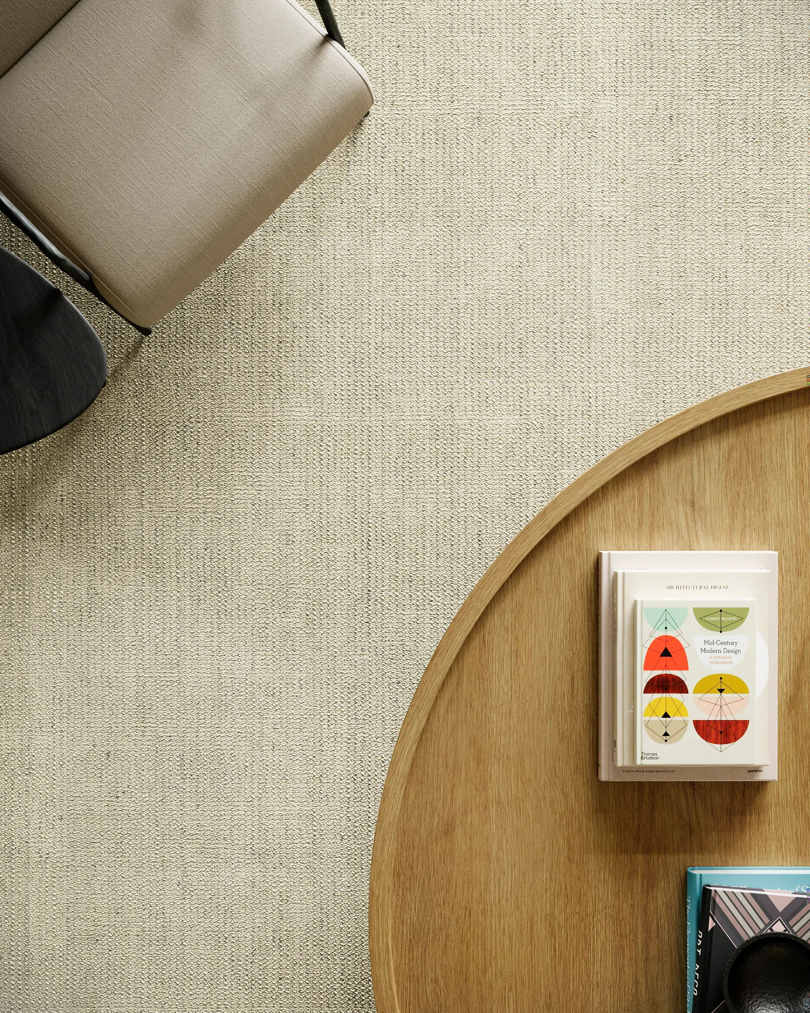 Overhead view of a modern living room with a beige 100% wool carpet, a beige chair, and a wooden coffee table with books