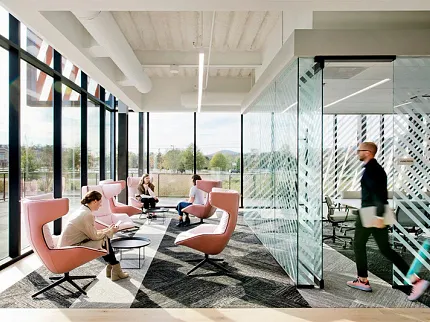 Contemporary Office Space with Commercial Carpet Tile Flooring Modern workplace with large windows, pink chairs, and commercial carpet tile flooring
