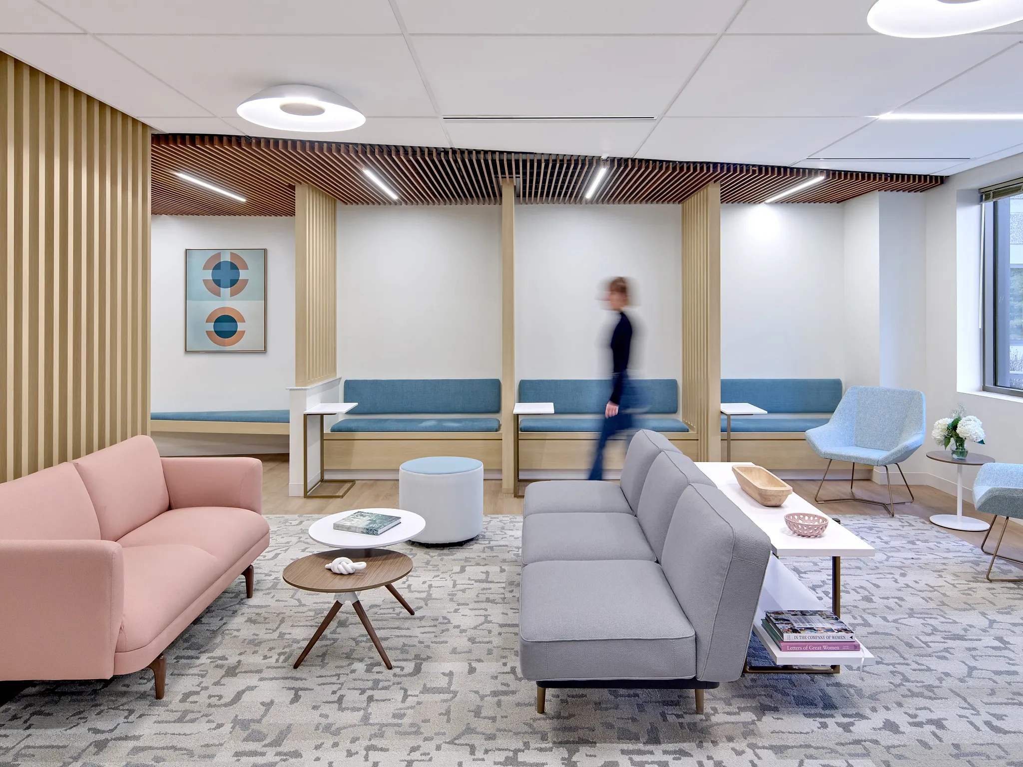 Modern healthcare facility waiting area with pastel-colored furniture and abstract carpet design