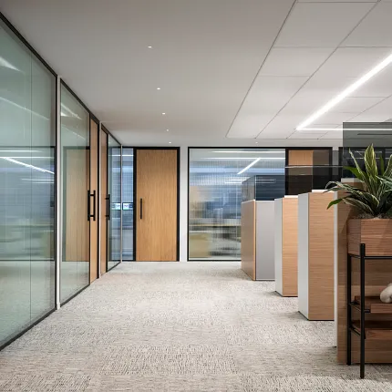 Modern workplace with commercial carpet tile flooring in neutral tones, featuring 18x36 inch dimensions, glass partitions, and wooden accents