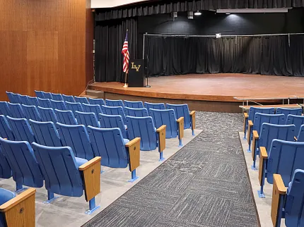 Durable carpet flooring for educational auditoriums Auditorium with blue seating and carpet flooring in an education facility
