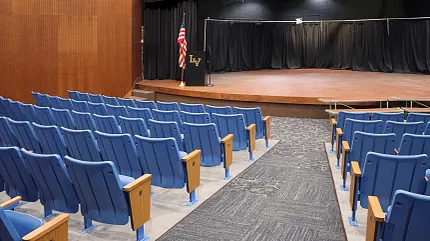 Durable carpet flooring for educational auditoriums Auditorium with blue seating and carpet flooring in an education facility