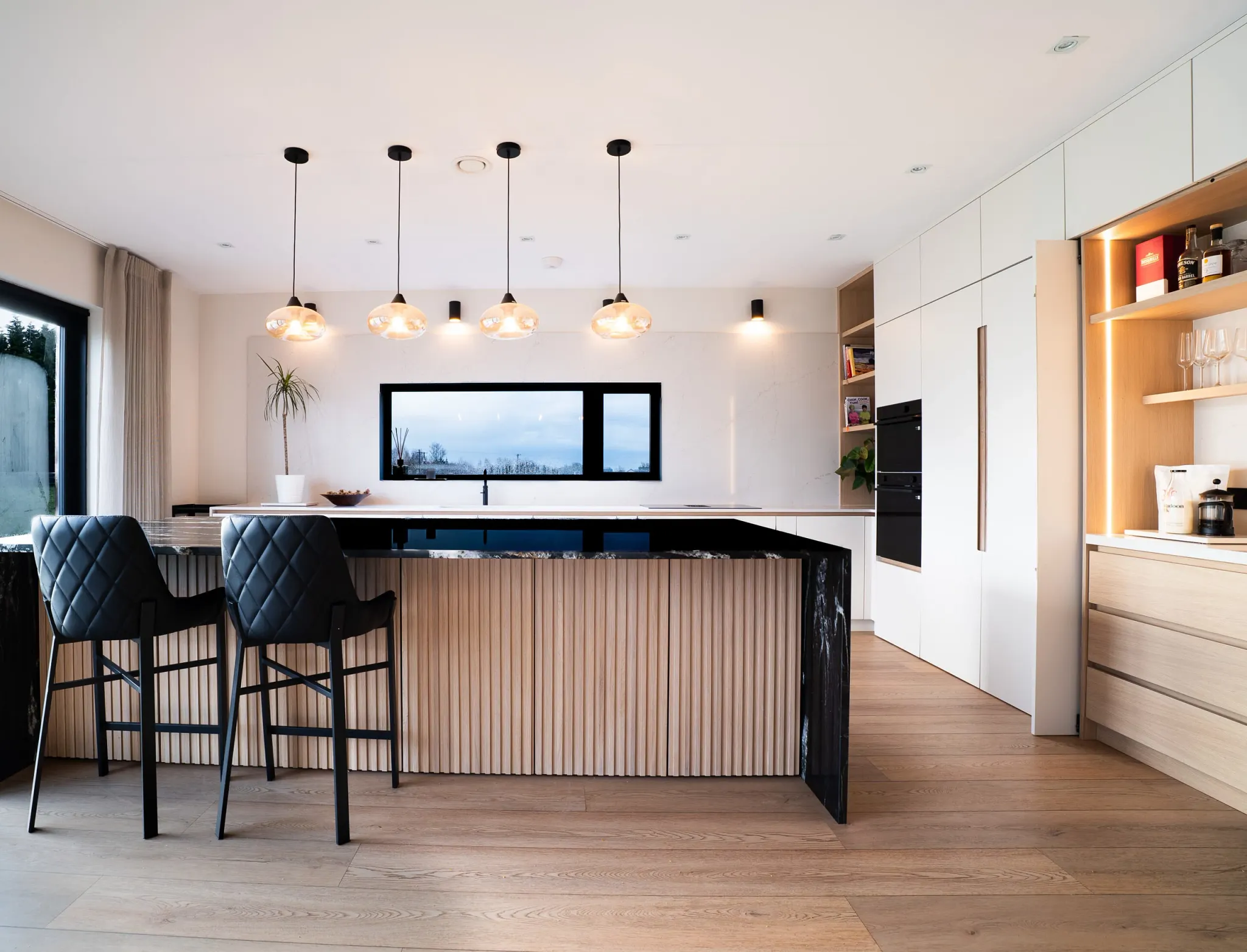 Modern kitchen with hardwood flooring and stylish lighting