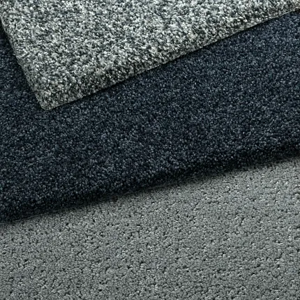 Durable gray carpet swatches for comfortable and easy-to-maintain home flooring Close-up of three carpet swatches in shades of gray, showcasing texture and durability for everyday home comfort