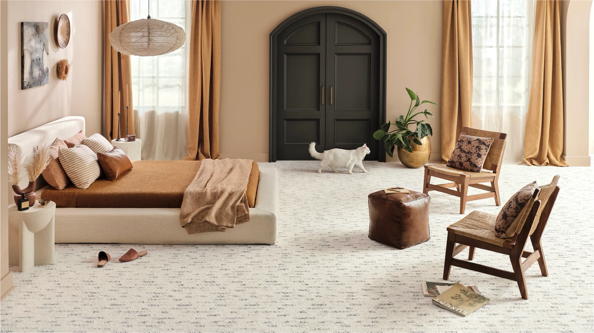 Bedroom with patterned carpet, a platform bed and a cat waling across the room