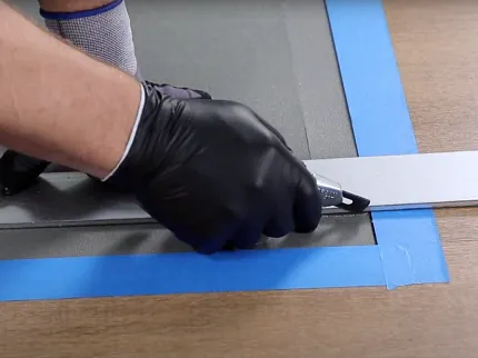 Flooring installation process with tools and techniques Person installing flooring with a utility knife and measuring tool