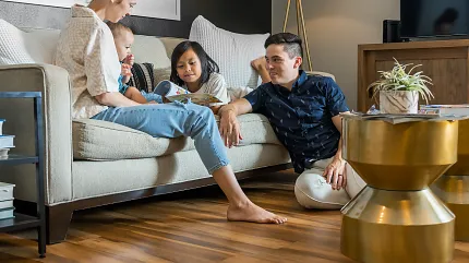 Coretec Residential WPC Luxury Vinyl Plank Flooring in Living Room - 48.03x4.96 inch Family enjoying time in a living room with Coretec Residential WPC luxury vinyl plank flooring in a warm wood look, 48.03x4.96 inch dimensions