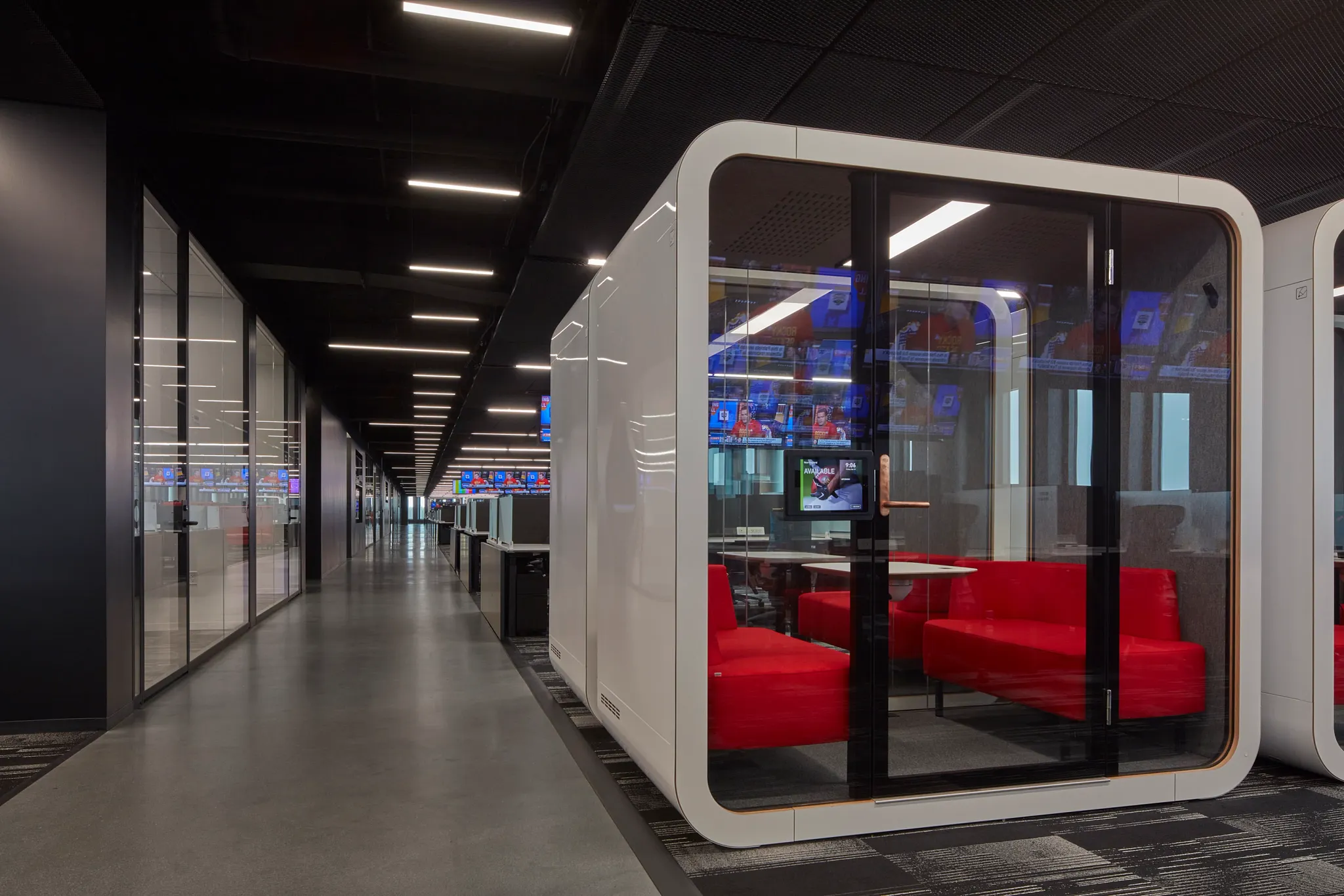 Modern workplace with glass meeting pods and commercial carpet tile flooring in a 24x24 inch size