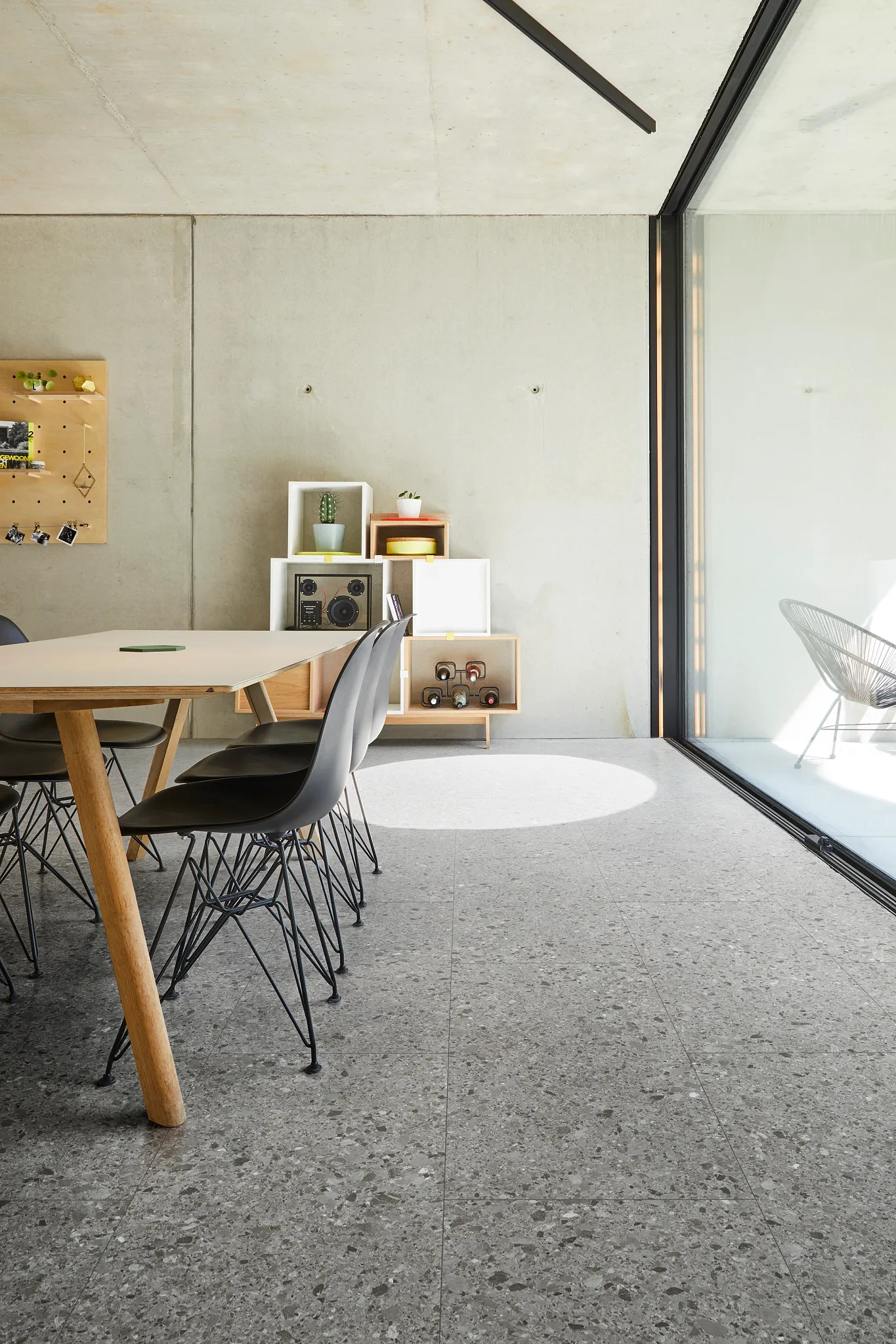 Modern dining room with large windows featuring stone look luxury vinyl tile flooring in a grey color