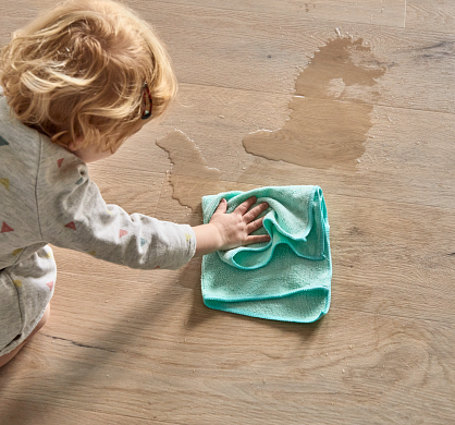 child cleaning water spill on COREtec vinyl flooring 