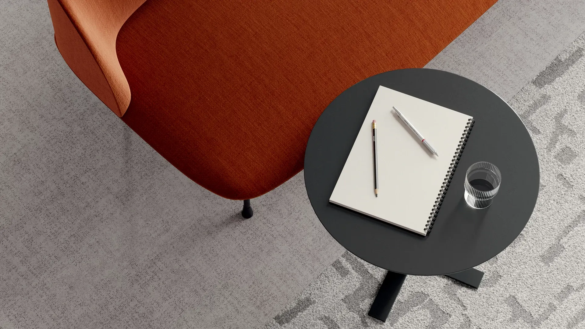 Modern office setting with a red-orange chair and a black round table on light gray commercial carpet tile
