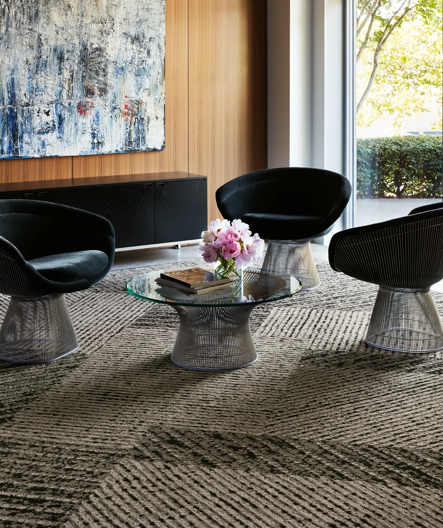 A beautiful interior sitting room with a bright big window, featuring commercial neutral patterned black and beige carpet tile
