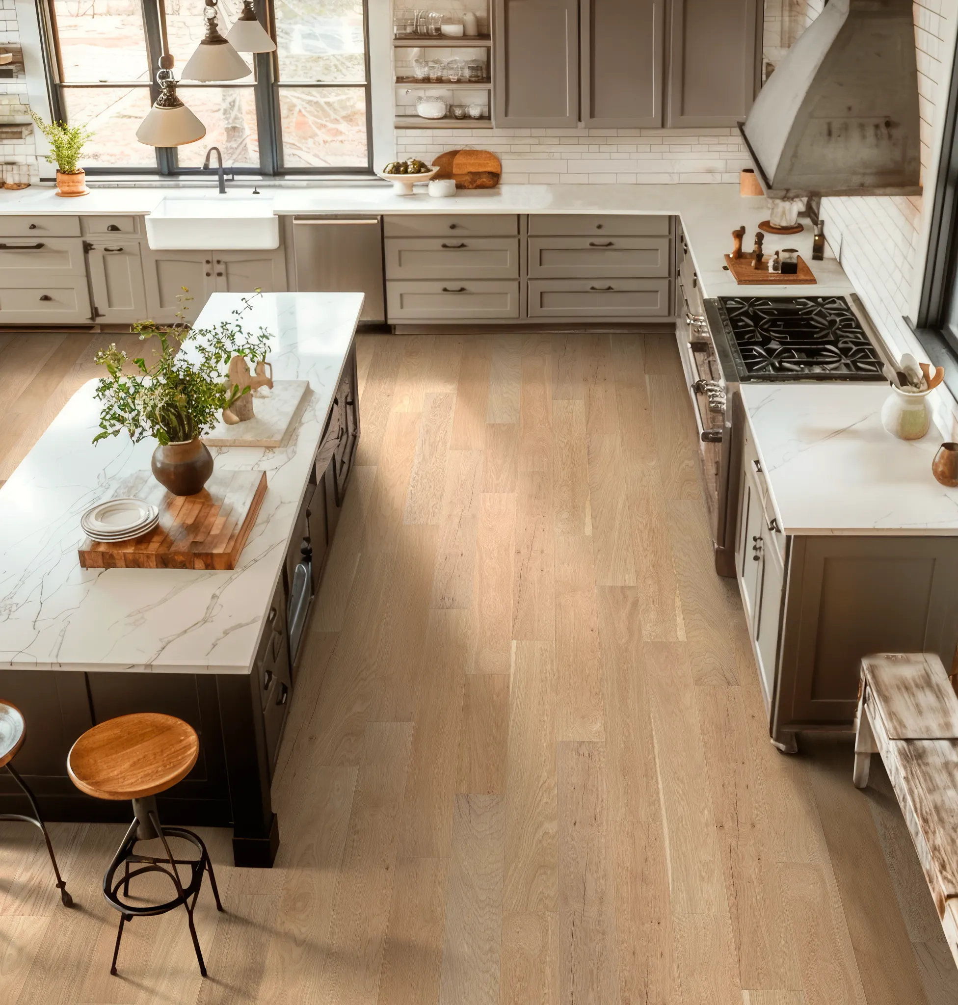 Modern kitchen with light hardwood flooring, marble countertops, and neutral cabinetry