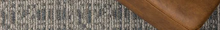 Blue and Beige Patterned Commercial Broadloom Carpet - 12 ft Width Commercial Broadloom Carpet in blue and beige pattern with a brown leather ottoman and a plant on a book