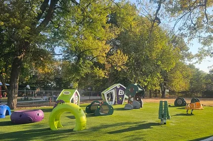 Vibrant outdoor play area for children Colorful playground equipment on green grass under trees