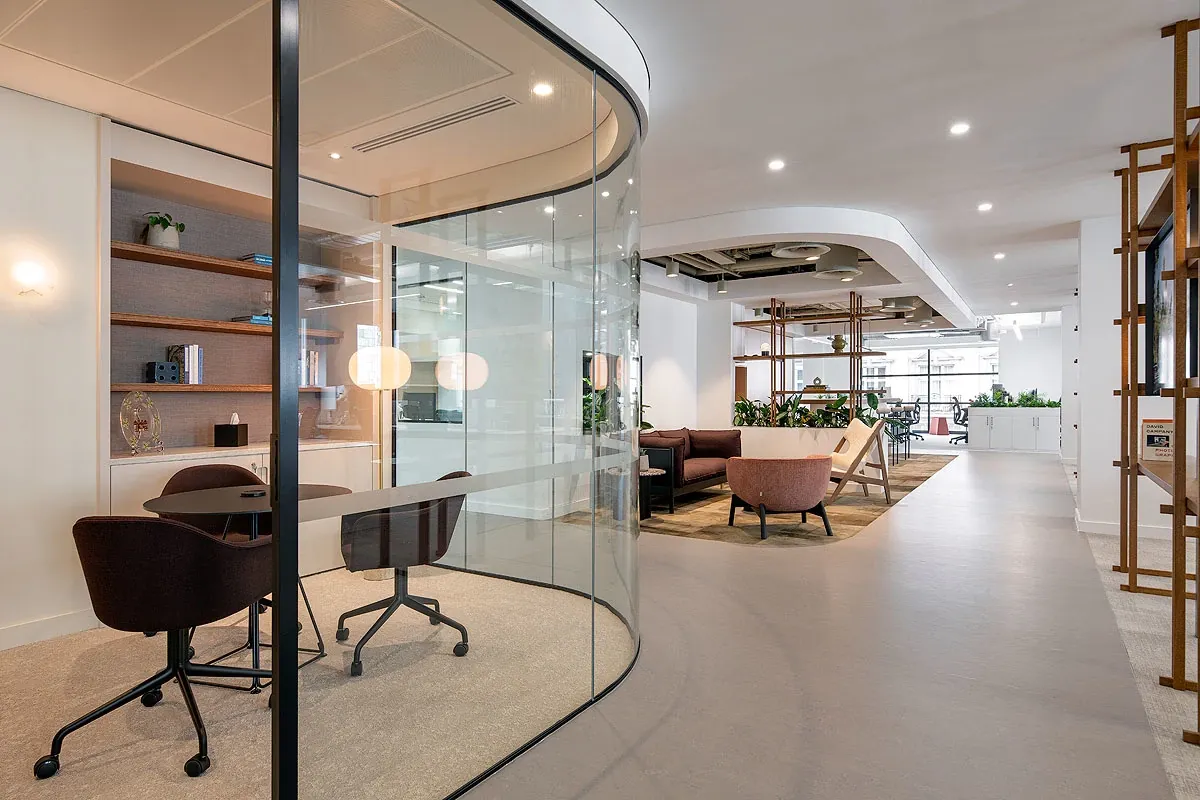 Espacio de oficina moderno con divisiones de vidrio y asientos elegantes