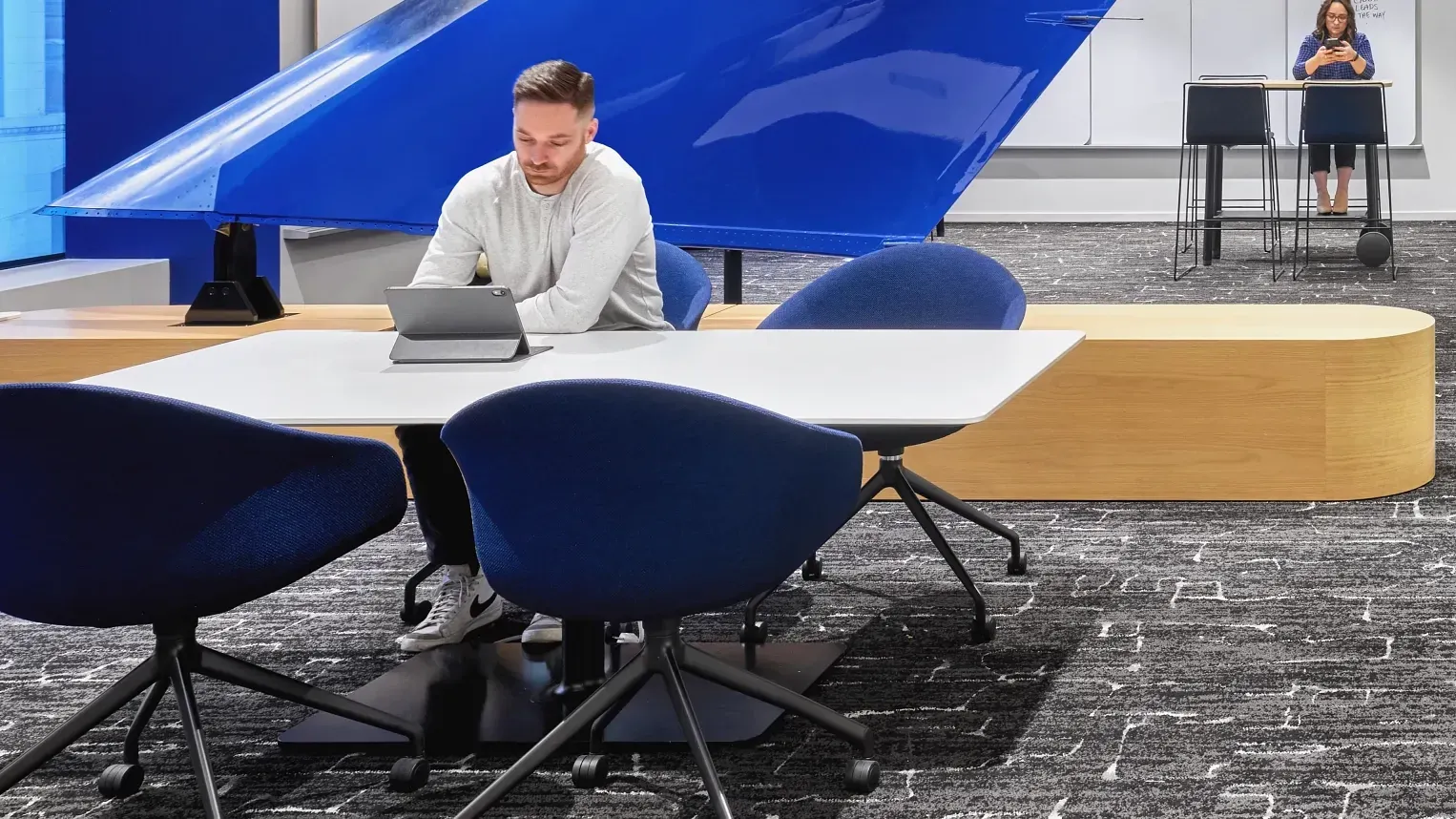 Modern office space with blue chairs and textured carpet flooring