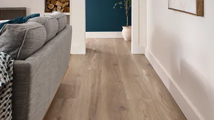 Wood Look Luxury Vinyl Plank Flooring in Modern Living Room Scene Modern living room with wood look luxury vinyl plank flooring, featuring a gray sofa and abstract wall art